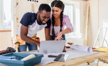 Two young homeowners preparing for home renovations by exploring different design plans on their shared laptop.