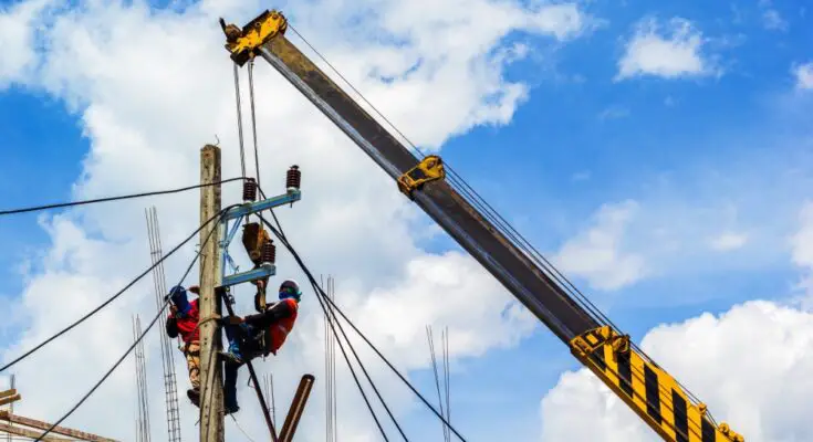 An electrical crew working on a utility pole. They're relying on quality rigging gear and supplies for hoisting.