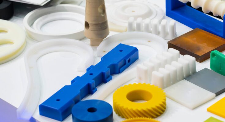 Multiple molded parts with different shapes, sizes, and colors placed next to each other on a white surface.