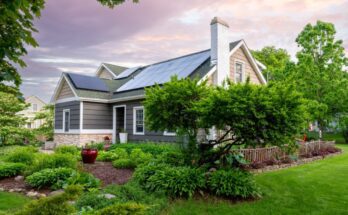 A beautiful East Coast-style residential home with roof-installed solar panels. The house is surrounded by lush landscaping.