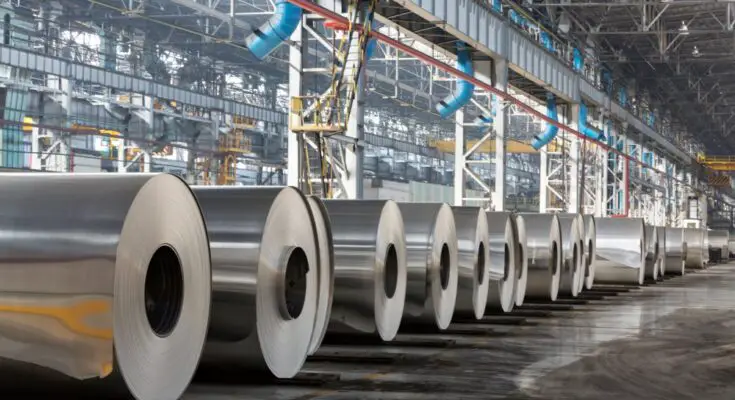 Large rolls of aluminum sheets in a warehouse facility. The rolls are lined up using proper storage standards.