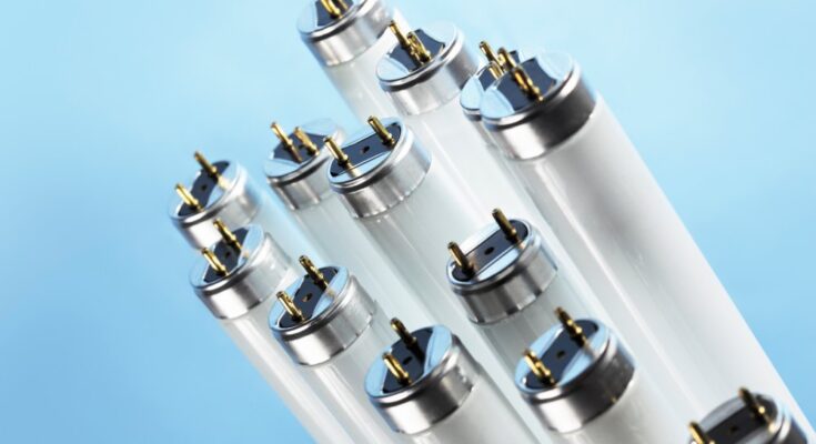 A close-up view shows thirteen fluorescent tube lights against a light blue background that gradually gets darker.