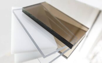 Several pieces of polycarbonate plastic lie on top of each other. Two are brown, two are white, and two are transparent.