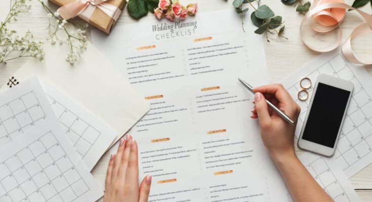 A woman holding a pen and looking over her wedding planning checklist to make sure she doesn’t break the bank.