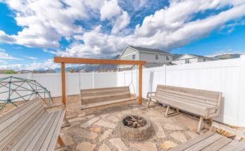 A small firepit surrounded by stone slabs and wooden benches. One of the benches is actually a swing.