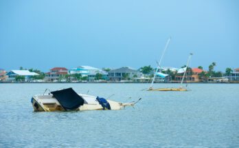 A boat going under water in the marina. There is a second boat behind it also going under the water.