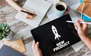 A person holds a tablet and stylus in their hands. The tablet reads "new product" and shows an image of a rocket.